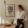 Black botanical branch poster styled in modern living room with neutral beige decor